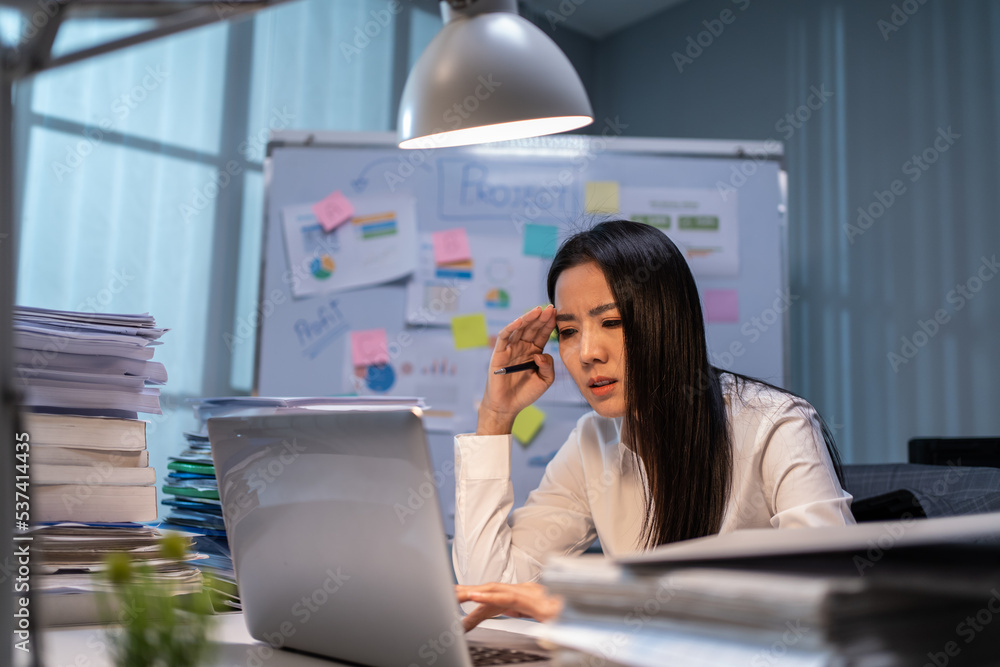 Asian frustrated businesswoman using laptop work in office at night. 