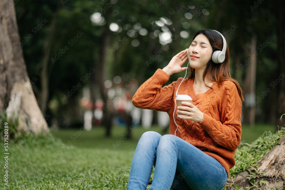 Beautiful young asian woman listening to music with headphone with feeling happy and relaxed, fresh 