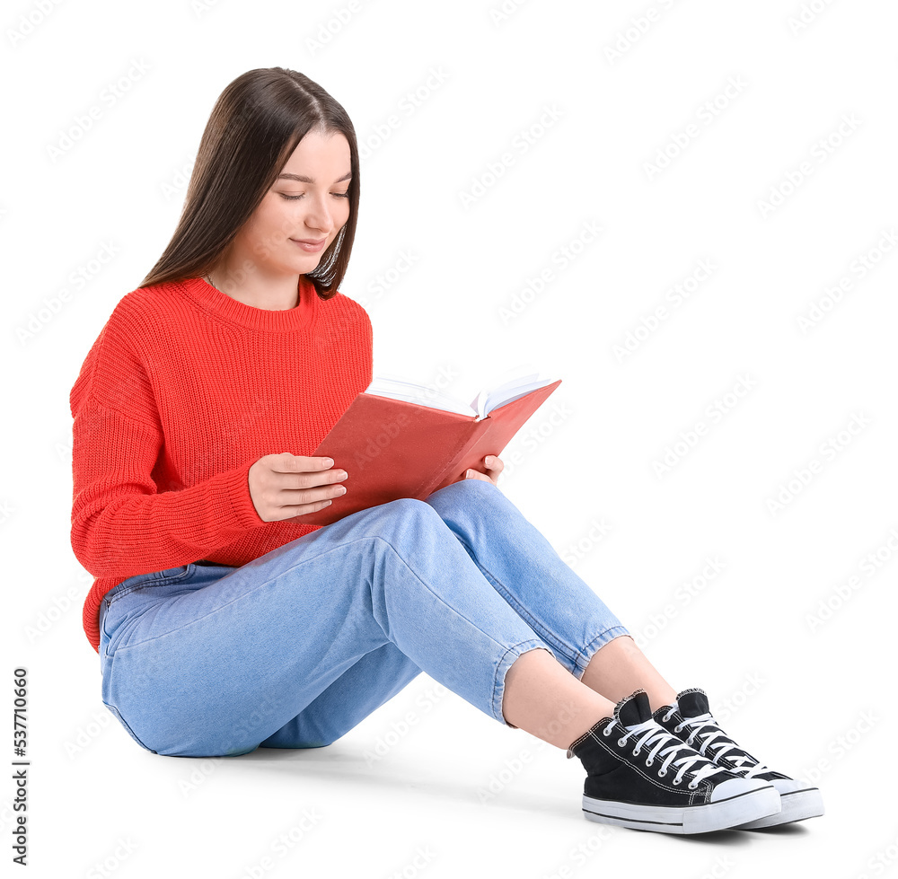 Young woman in red sweater reading book on white background