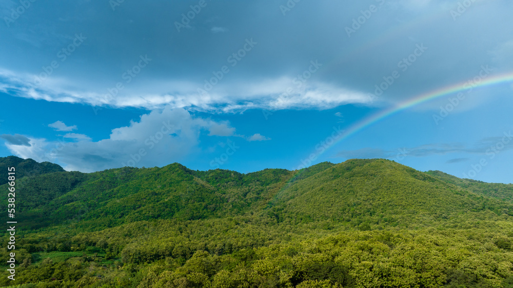 山上天空中的彩虹，在大自然中飞行的全景，雨中的彩虹，鸟瞰图