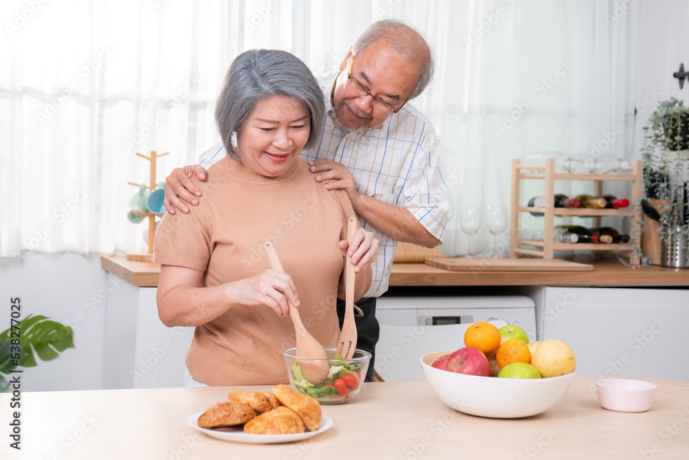 满足于在厨房里一起烹饪面包、蔬菜和水果的老年夫妇