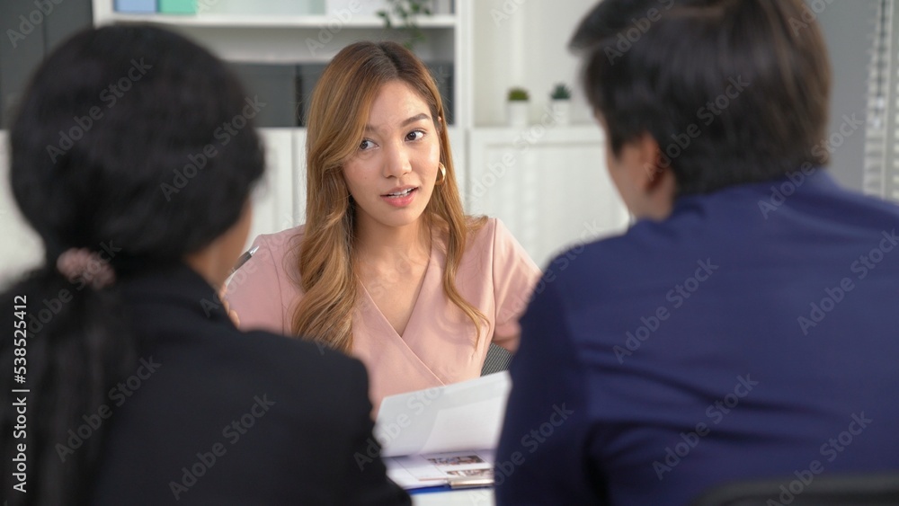 A young female asian candidate tries to impress her interviewer by being competent. International co