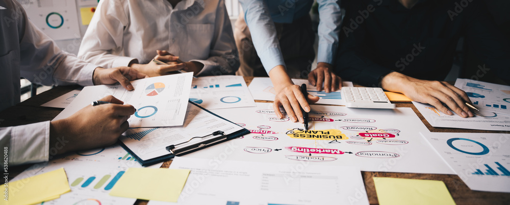 Close-up of businesspeople hands pointing a business plan data and donut chart, analyzing financial 