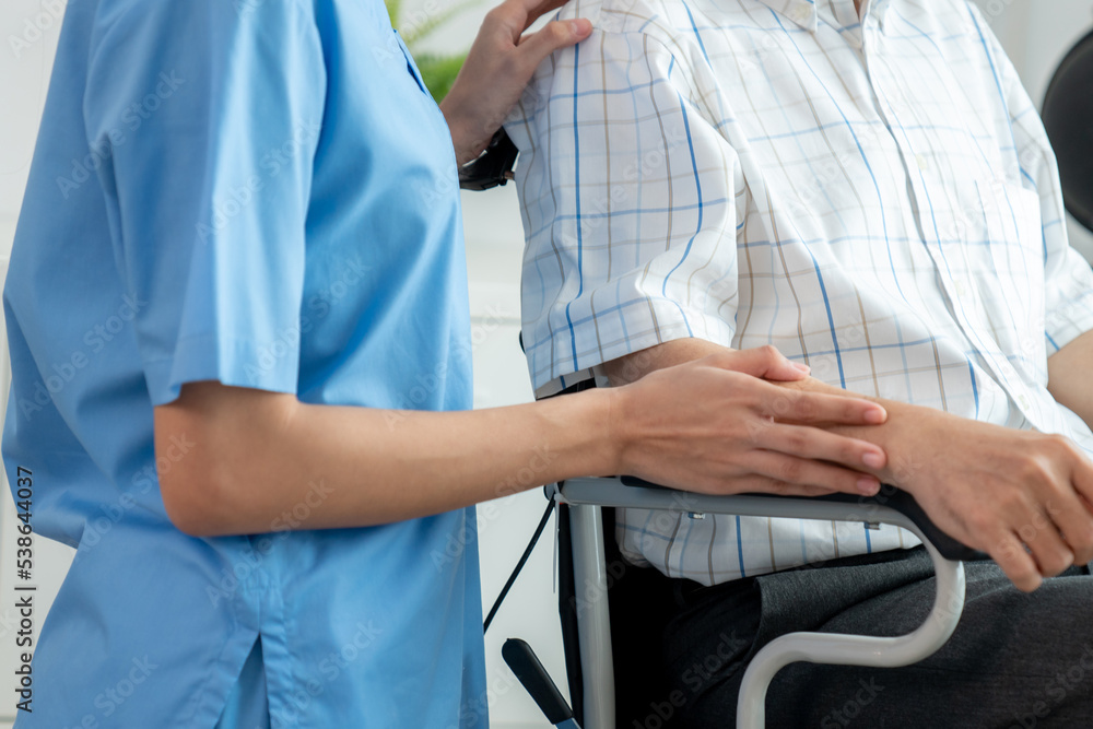 Happy positive asian nurse giving support and touching contented senior man with love. Nursing home 