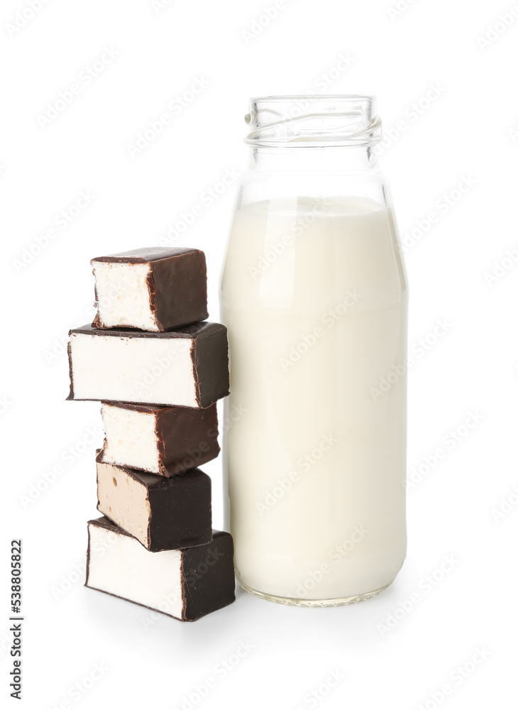 Bottle of milk and tasty candies on white background