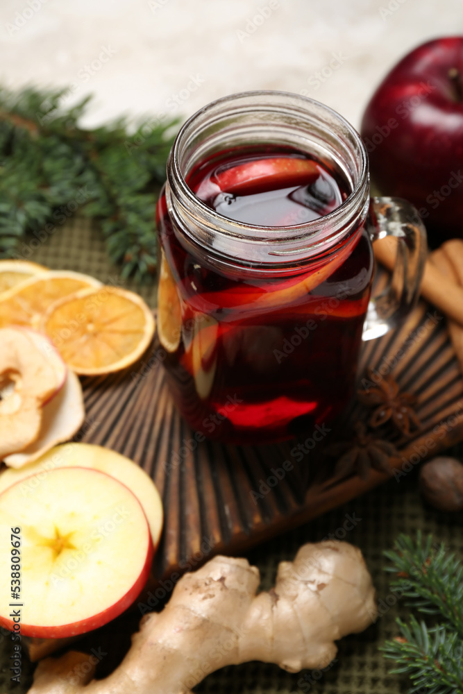 Mason jar with tasty mulled wine on table, closeup