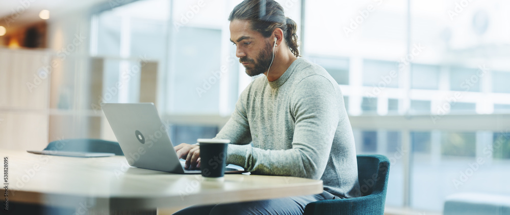 Young businessman working on a laptop in a co-working space