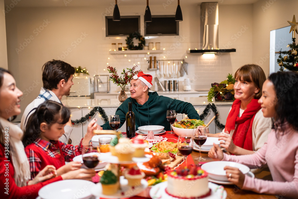 Multi-ethnic big family celebrating Christmas party together in house.