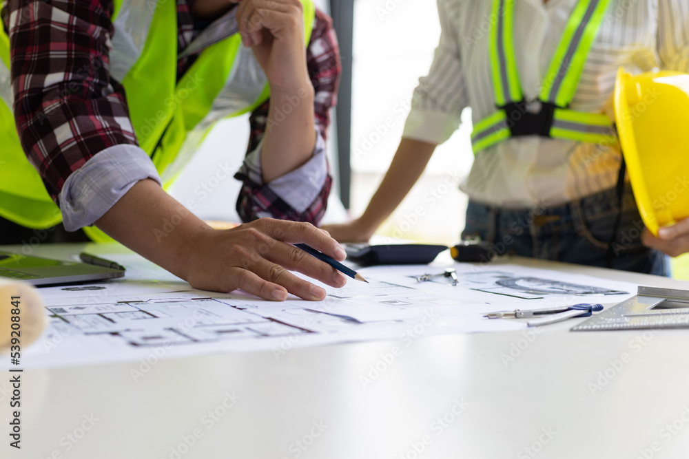 Architect and engineer colleagues brainstorm design work on blueprint planning ideas of construction