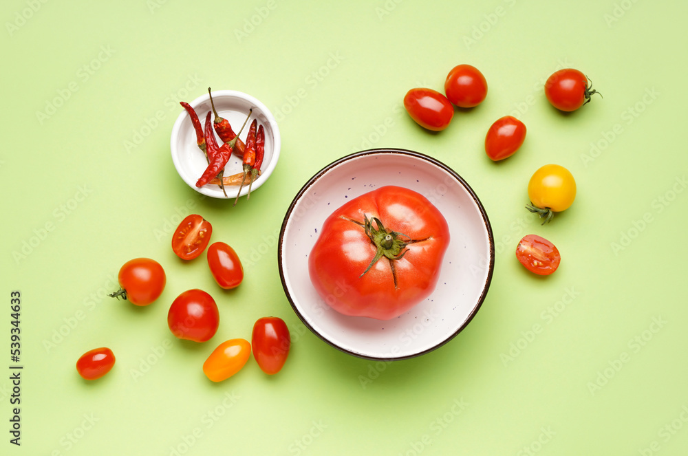 Composition with fresh tomatoes and dried chili peppers on green background