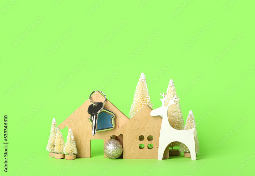 House figures with key and Christmas decor on green background