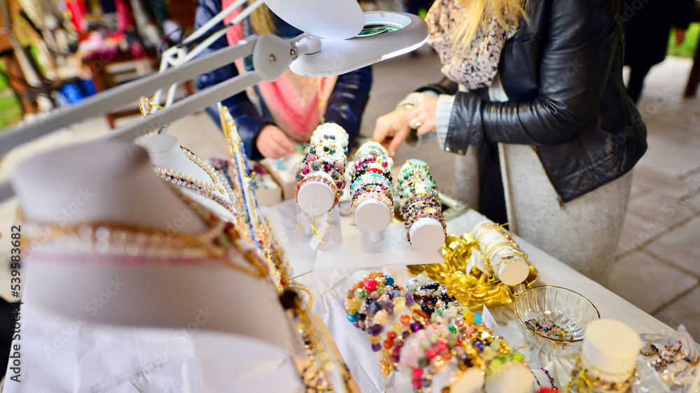 Beautiful woman trying on hand made bracelets with gemstones.