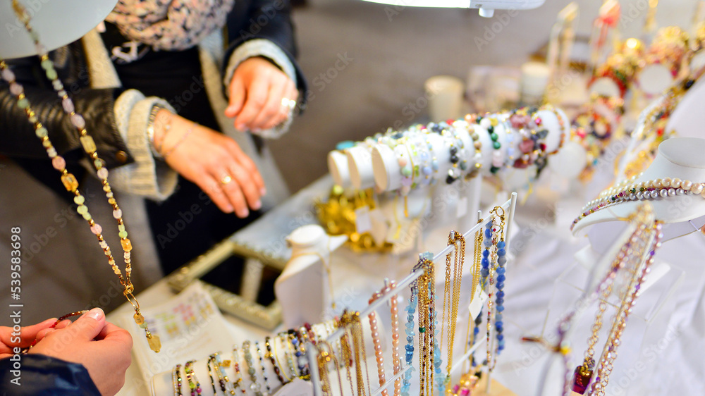 Beautiful woman trying on hand made bracelets with gemstones.