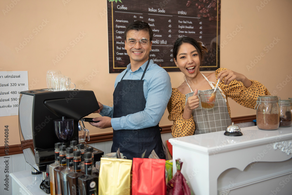 Smiling asians small business owner waiter barista with female auditor holding clipboard standing at