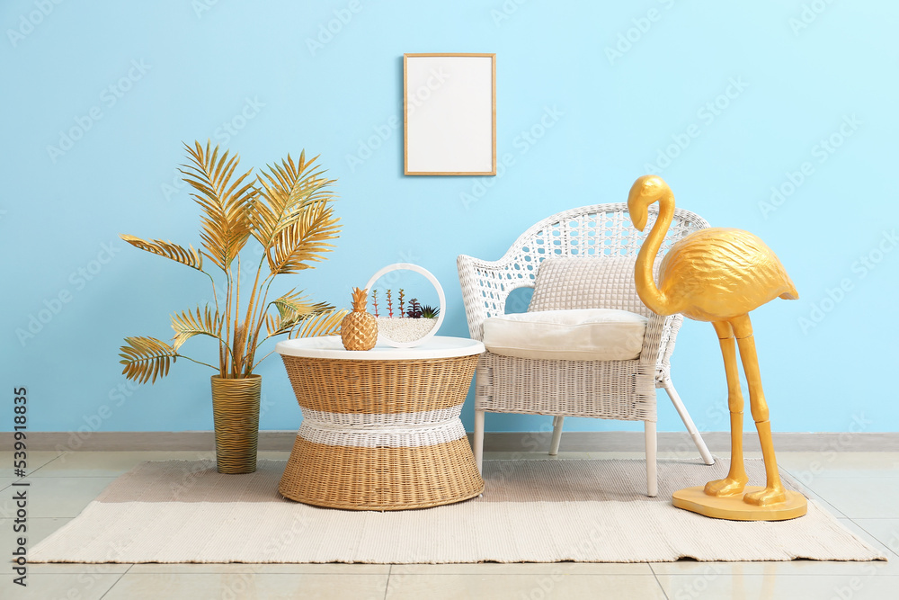 Stylish golden flamingo, armchair, table and palm leaves in room interior