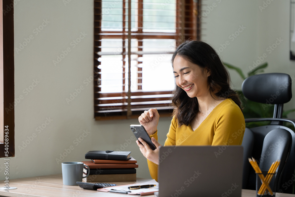 在办公室用手机工作的女人