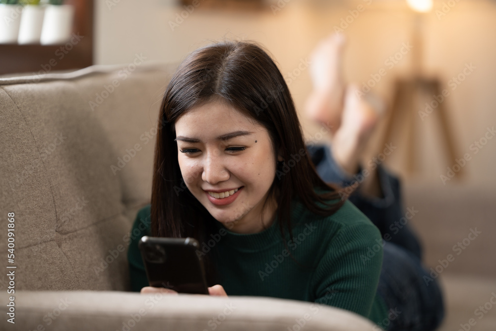 front view of woman lying on sofa and play tablet at home