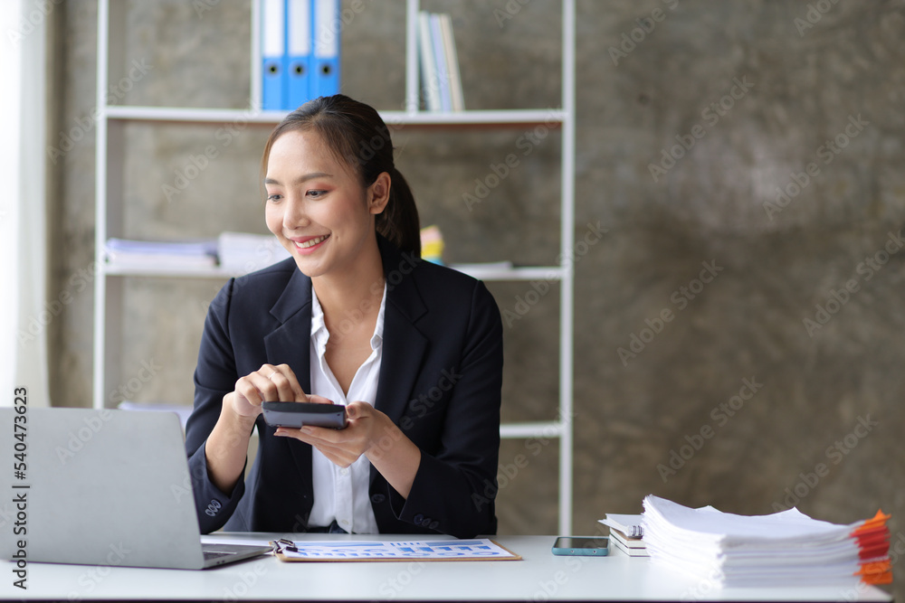 Business woman working on laptop and financial documents, female accountant in the office analyzes t