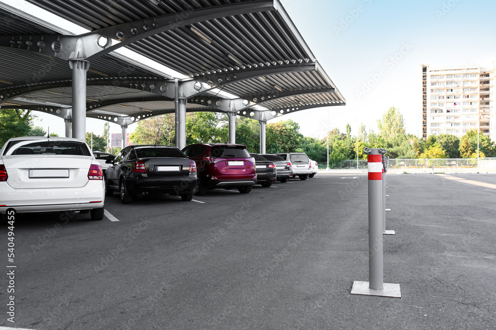 Limiters with red and white stripes on parking under canopy