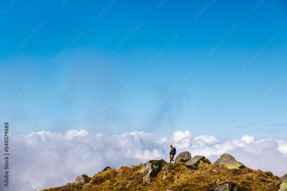 青空と雲と石だらけの登山道