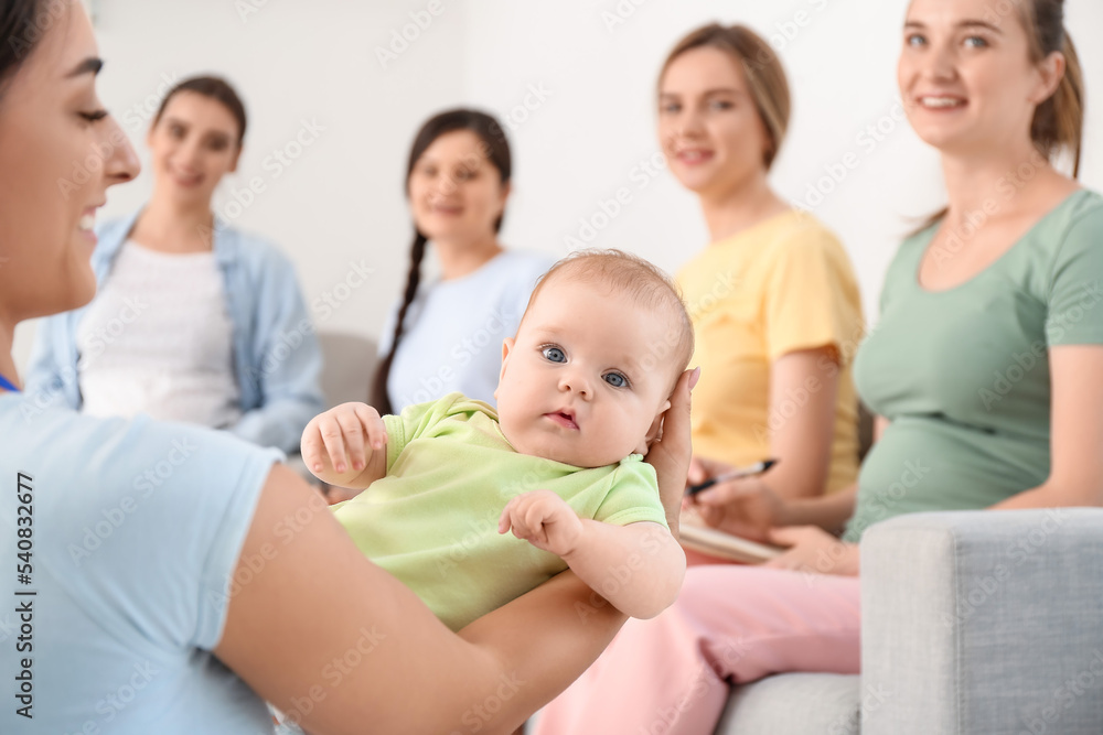 Female speaker with little baby giving course for expectant mothers in class