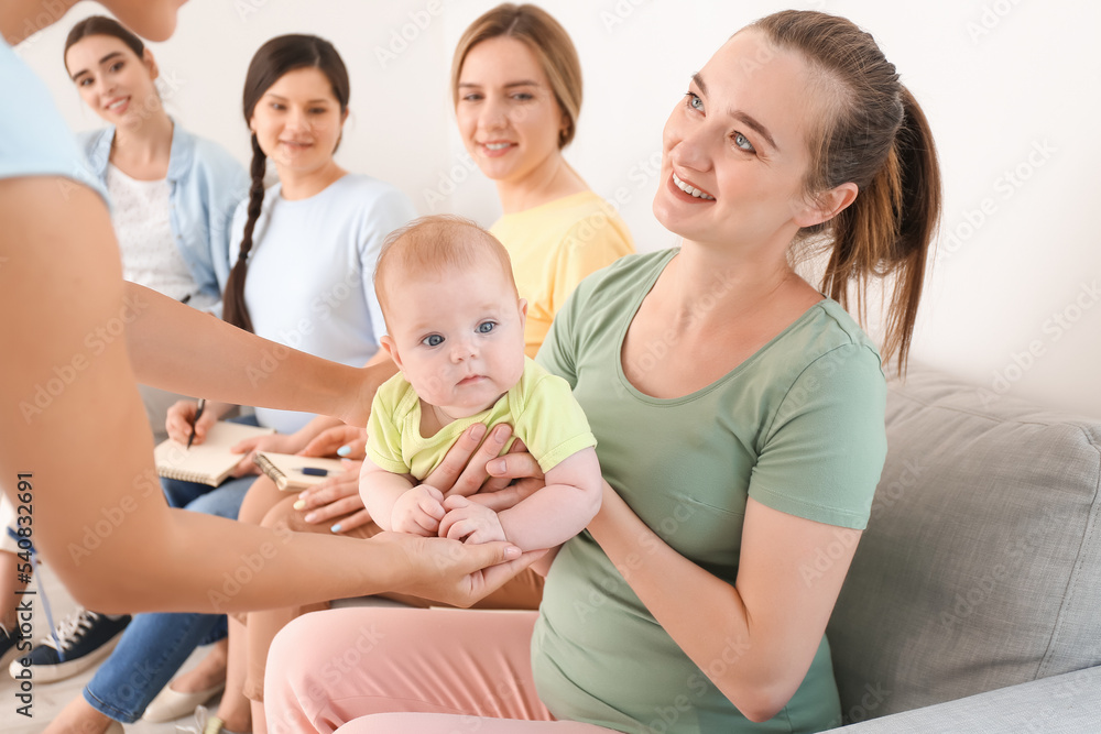 Female speaker with little baby giving course for expectant mothers in class