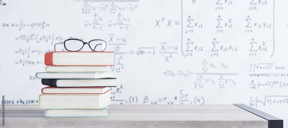 Close up of stacked books and glasses on white mathematical formulas background. School and educatio