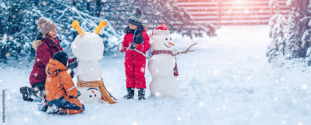 一家人在雪地公园里骗一个可爱的雪人。