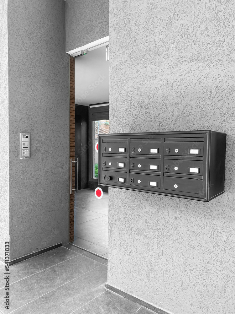 Modern mailboxes on grey wall in residential building