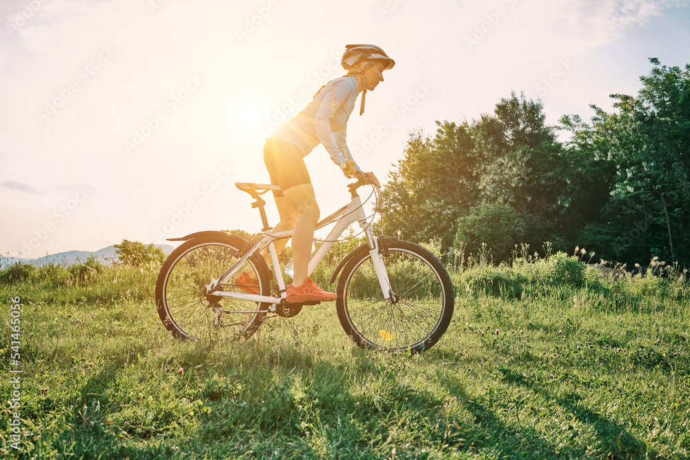 Cyclist Woman riding bike in helmets go in sports outdoors on sunny day a mountain in the forest. Si