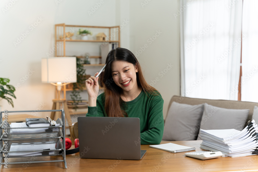 桌上放着笔记本电脑的亚洲女孩。