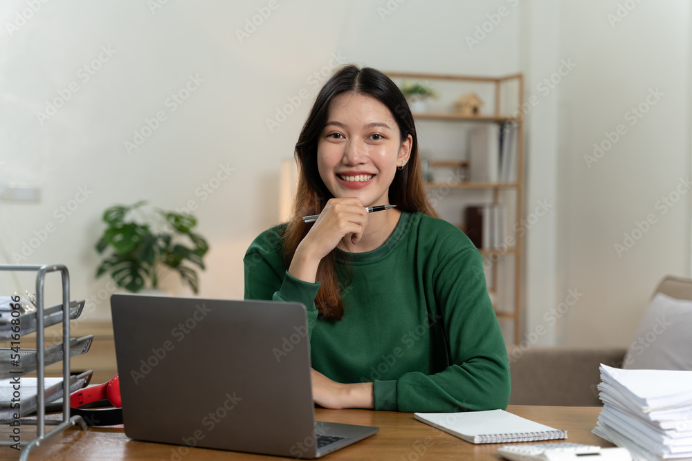 桌上有笔记本电脑的亚洲女孩。