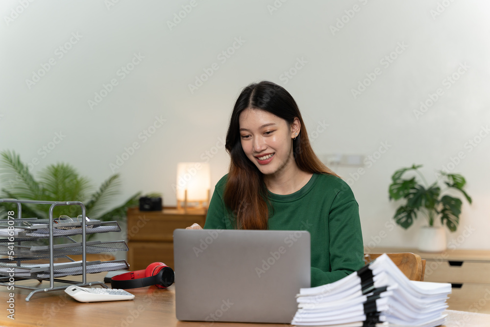 桌上放着笔记本电脑的亚洲女孩。