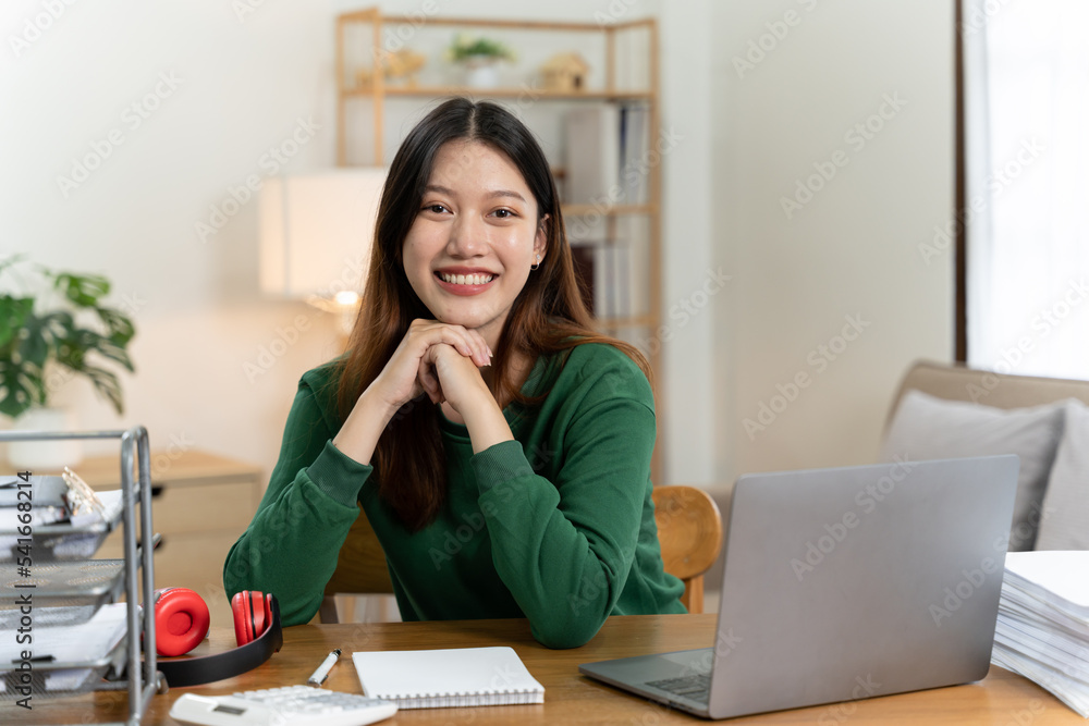 桌上有笔记本电脑的亚洲女孩。