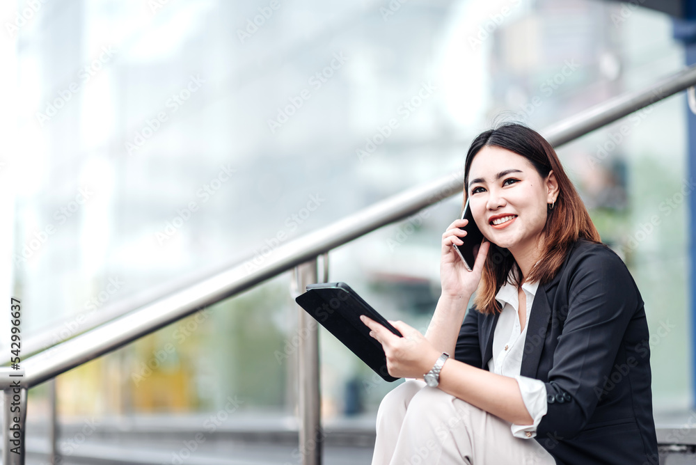 Young Asian businesswoman talking on phone and using tablet. Beautiful woman passenger has mobile ca