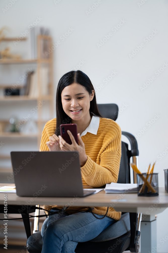 幸福感迷人的穿着黄色衬衫的亚洲女人拿着电脑笔记本电脑思考想法