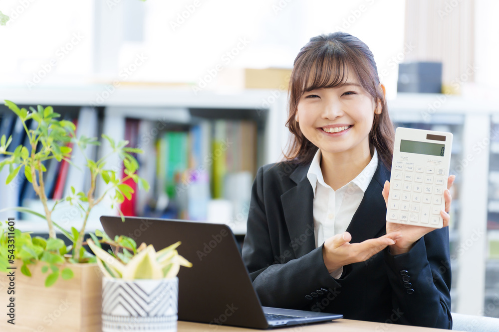 オフィスで電卓を持つ女性