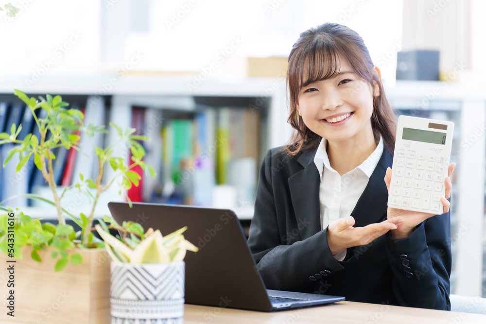 オフィスで電卓を持つ女性