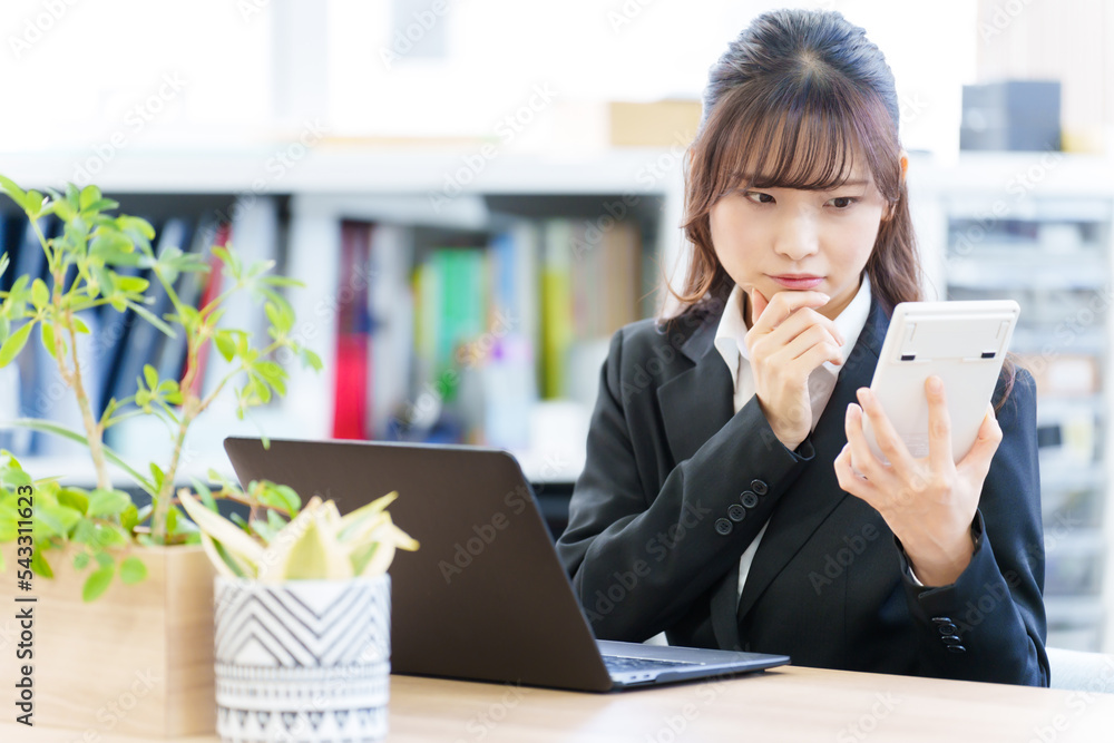 電卓を持って考える女性