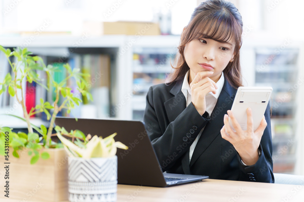 電卓を持って考える女性