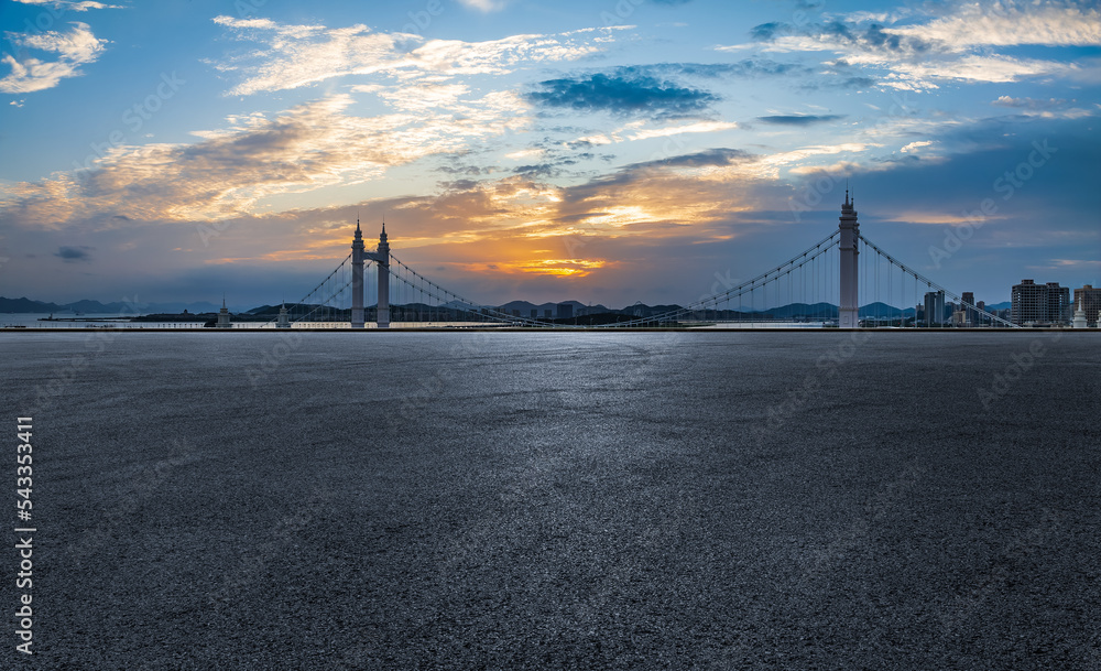 日落时，空旷的沥青路桥与城市天际线