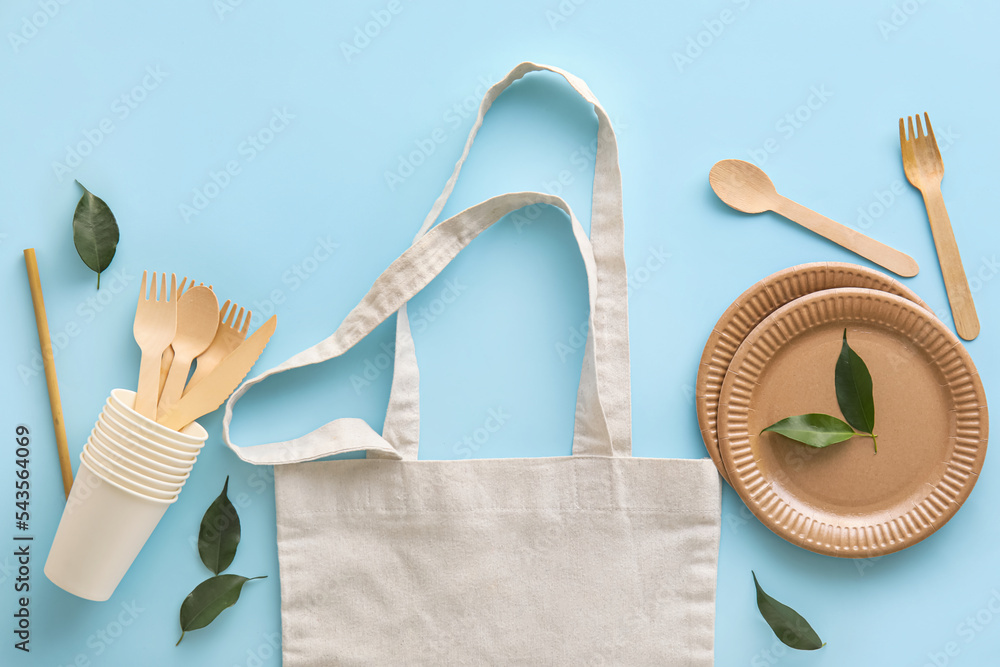 Tote bag, Eco tableware and plant leaves on blue background