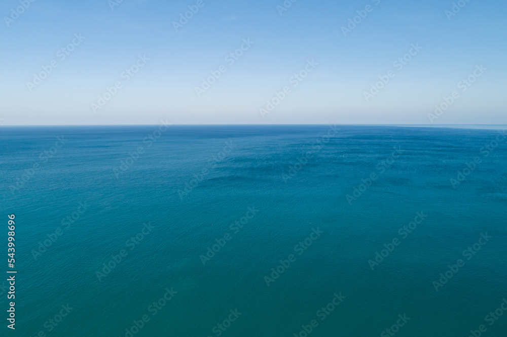 Aerial view of a blue sea surface water texture background and sun reflections Aerial flying drone v