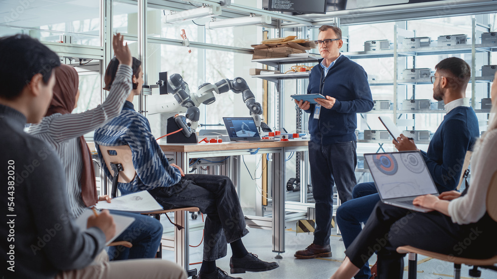 University Robotics Lecture: Teacher Explaining Engineering to Students by Using Robot Arm. Diverse 