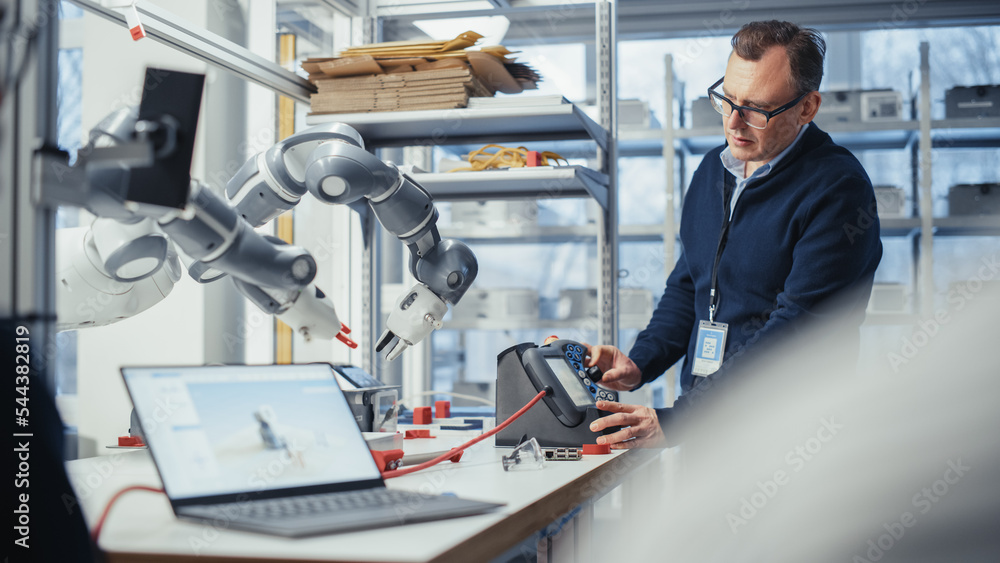 Male Senior Developer Works on Engineering Project, Changes Robotic Hand Position with Lever. Empowe