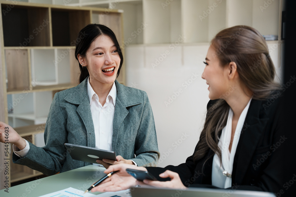 女性同事一起使用笔记本电脑进行统计分析。