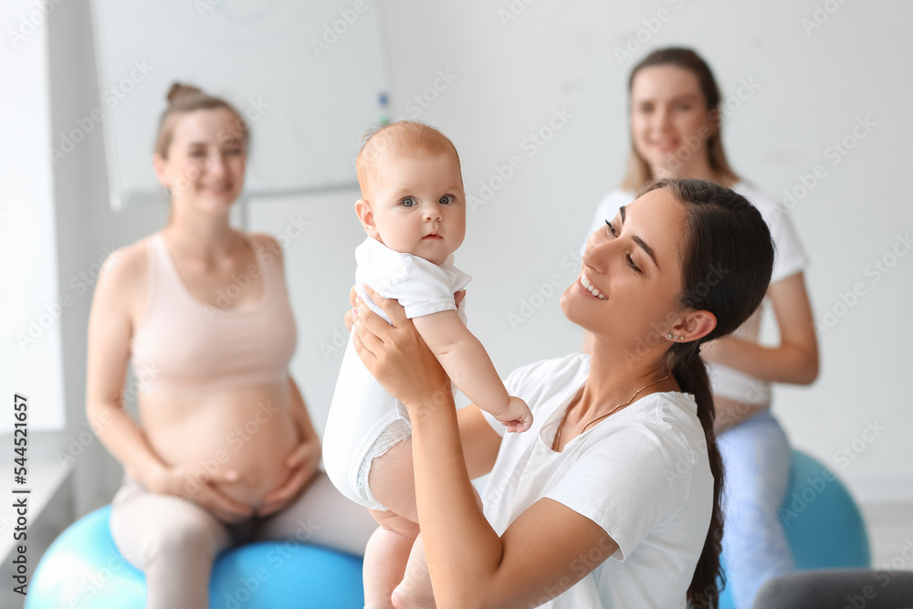 带着婴儿和孕妇的女教练在健身房训练