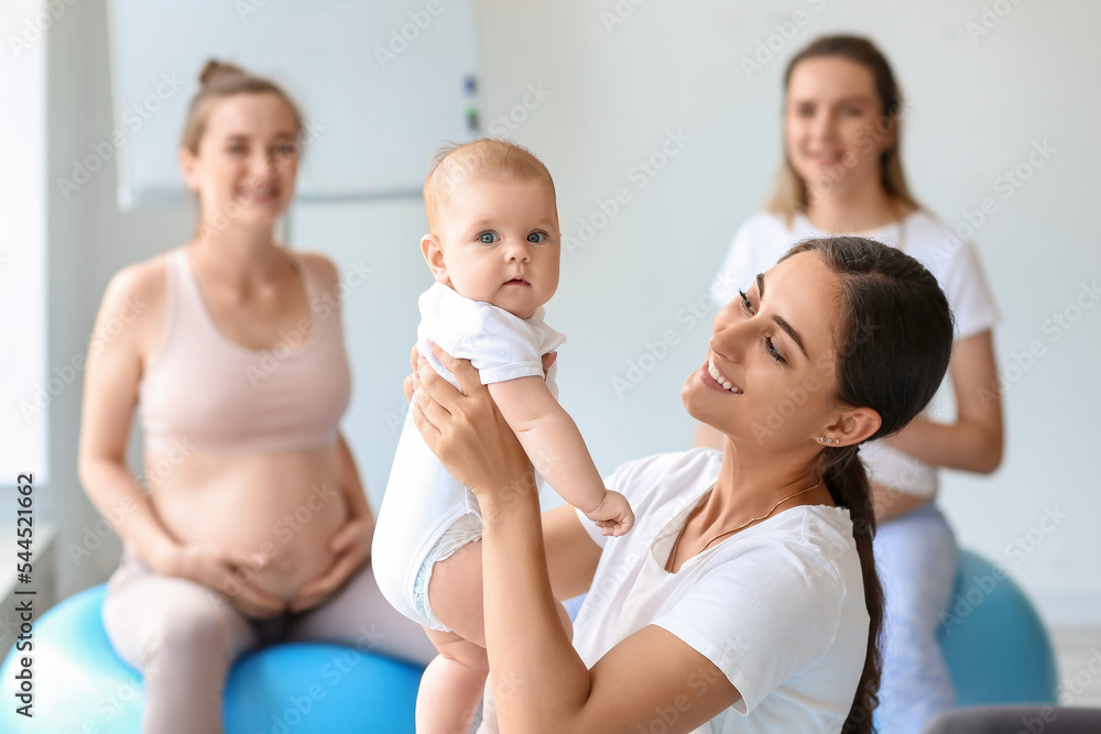 带着婴儿和孕妇在健身房训练的女教练