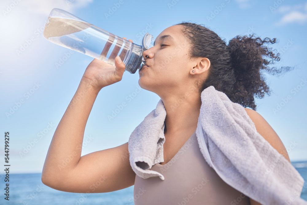 Water, fitness and woman with a drink after exercise, workout or training by the sea. Sports, motiva