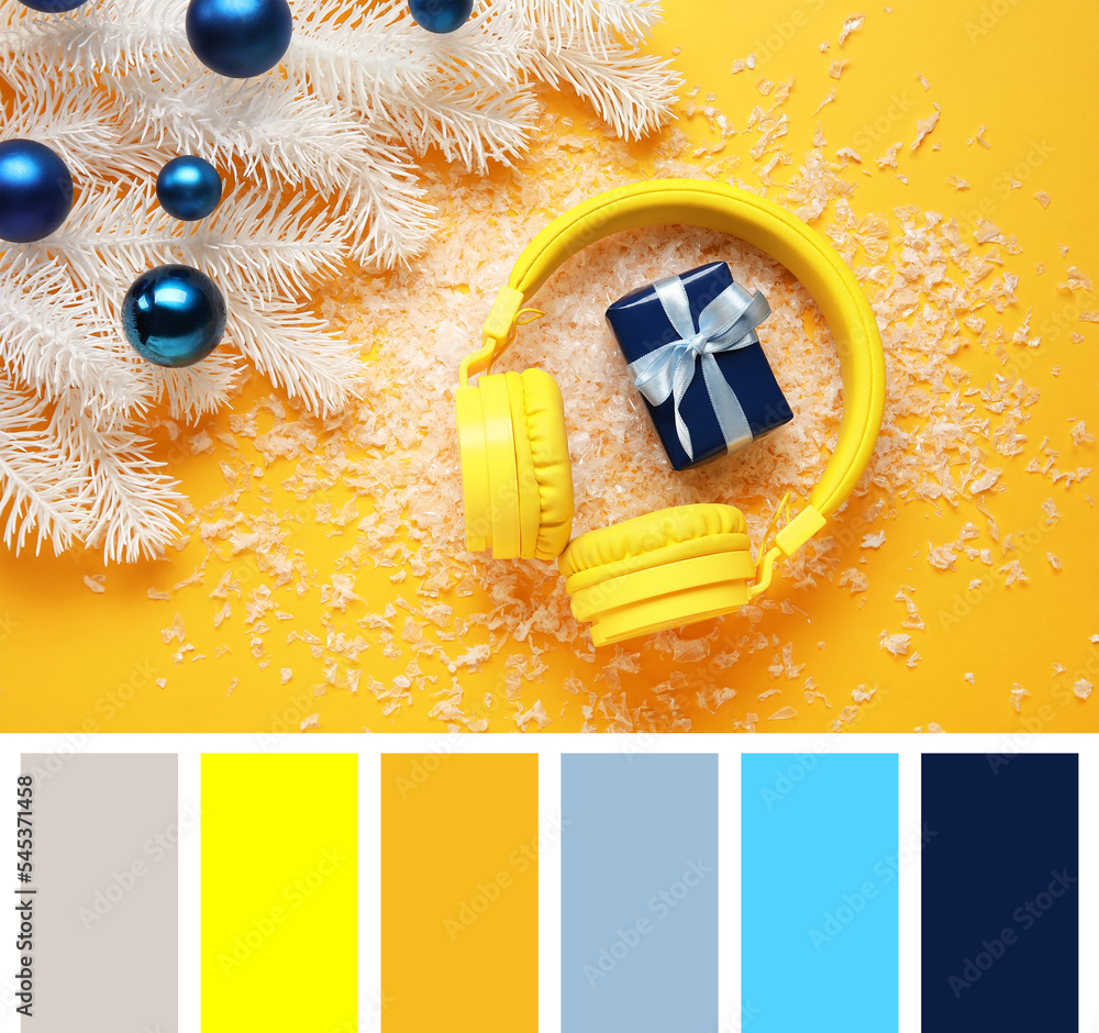 Composition with modern headphones, Christmas gift, snow and decor on yellow background. Different c